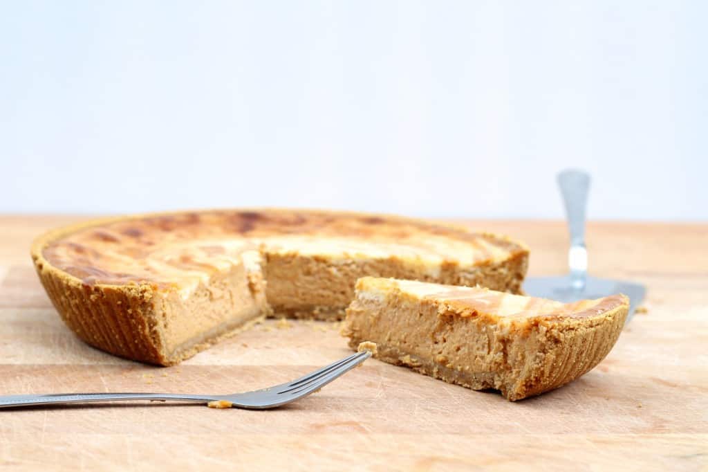 easy pumpkin swirl cheesecake on cutting board with piece sliced