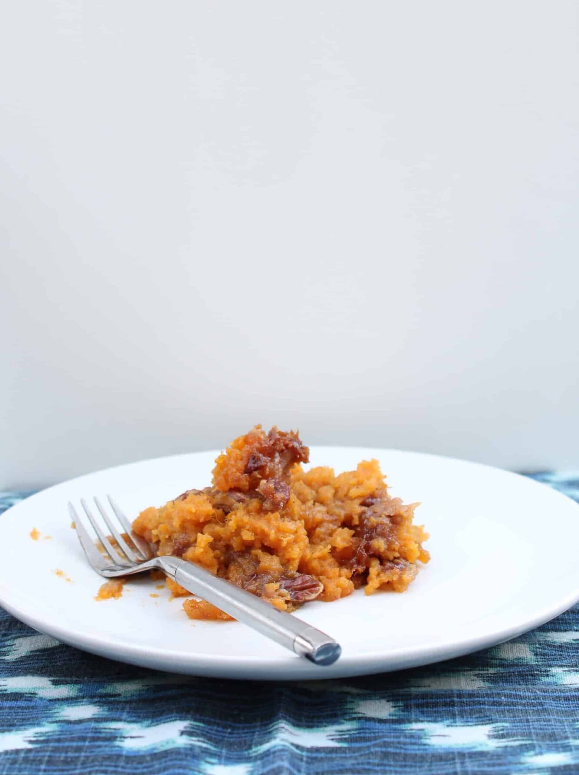 plate with a serving of sweet potato casserole with fork